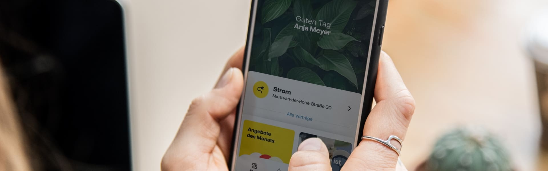 Hand hält Smartphone. Auf dem Bildschirm ist die geöffnete Vattenfall-App zu erkennen.